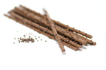 Chocolate sticks with chocolate granules on white background