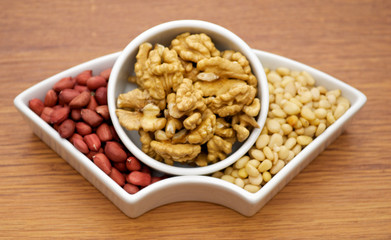 White plats with walnuts, peanut and pine nut