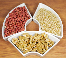 White plats with walnuts, peanut and pine nut