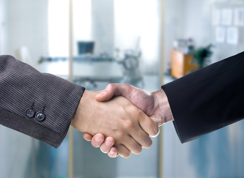 Business handshake in over a blurred office background
