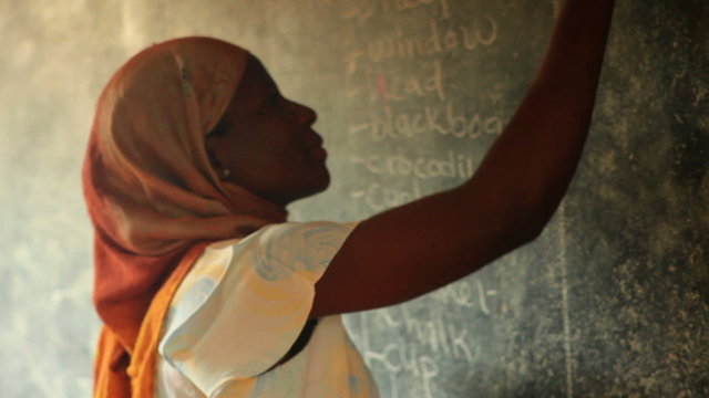 Close up of a schoolteacher in a full classroom in Kenya.