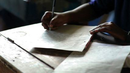 Student studying and taking a test in a school in Africa, African