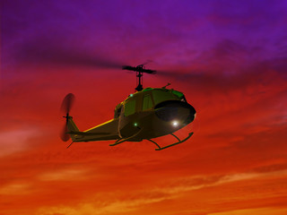 Fototapeta na wymiar Flying helicopter UH-1and red sunset