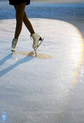 Woman’s Legs in White Ice Skates