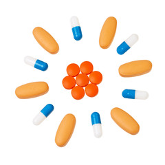 Colorful pills in circular pattern over white background.