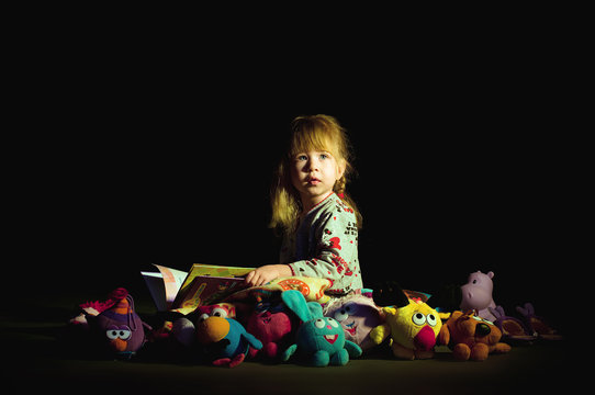 Little girl reading book before goes to sleep