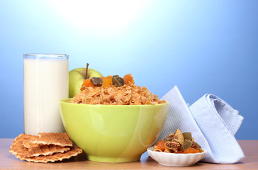 tasty cornflakes in green bowl, apples and glass of milk