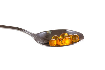 Spoon with pills isolated on white