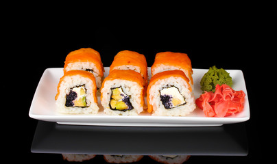 Tasty rolls served on white plate isolated on black