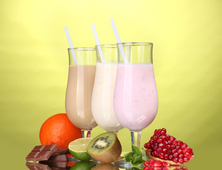 Milk shakes with fruits and chocolate on green background