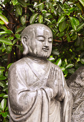 praying marble buddha in the rain