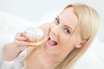 Beautiful woman eating tasty donut