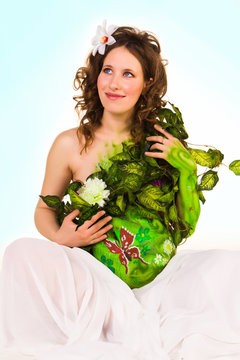Pregnant woman with body-art with green leaves