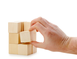 Obraz premium The hand establishes a wooden cube