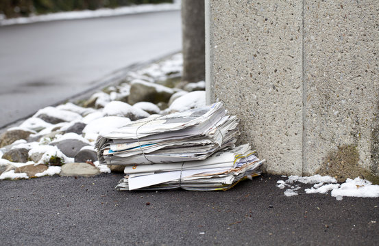stack of newspaper on a winter street