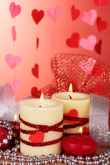 candles for Valentine's Day on wooden table on red background