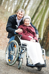 old senior woman in wheelchair with careful son