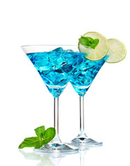 Blue cocktail in martini glasses with ice isolated on white