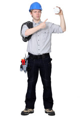 electrician pointing at the object he is holding