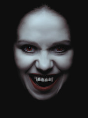 woman vampire with fangs on a black background - obrazy, fototapety, plakaty
