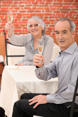 Elderly couple drinking champagne