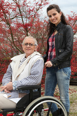 Young woman pushing an elderly lady in a wheelchair