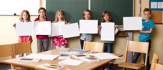 Kinder präsentieren Bilder im Kunstunterricht