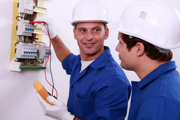 Electrical safety inspectors verifying central fuse box