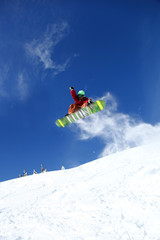 Naklejka na ściany i meble Snowboarder jumping przeciw błękitne niebo