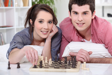 Young man and young woman playing chess