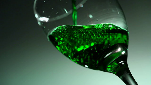 Glass with bright wine green flowing in it