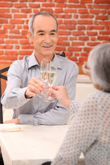 senior couple drinking champagne in a restaurant