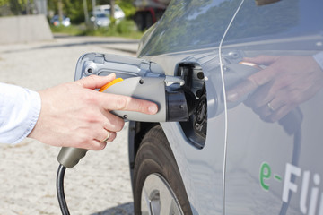 Tankstutzen und Zapfpistole bei einem Elektroauto