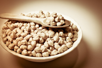 Chickpeas in a bowl and wooden spoon. Retro.