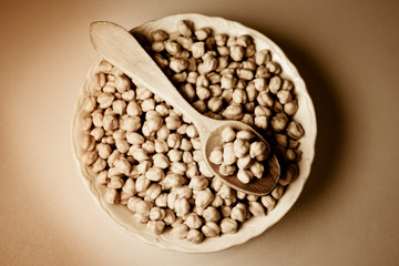 Chickpeas in a bowl and wooden spoon. Retro.