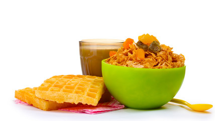 tasty cornflakes in green bowl and glass of milk isolated