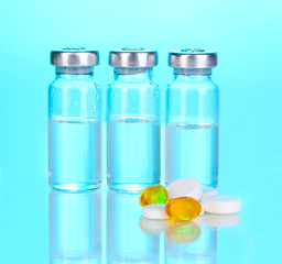 Tablets and ampoules on blue background