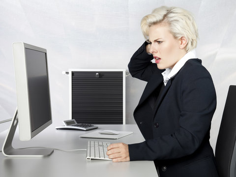 Stressed looking woman at her desktop in the office
