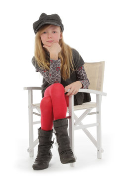 fillette posant avec v&ecirc;tements hiver sur chaise r&eacute;gisseur