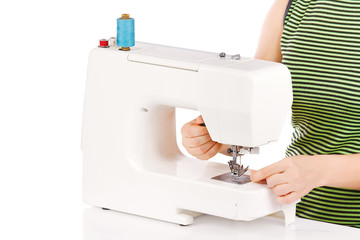 Woman is sewing on the sewing machine on a white background