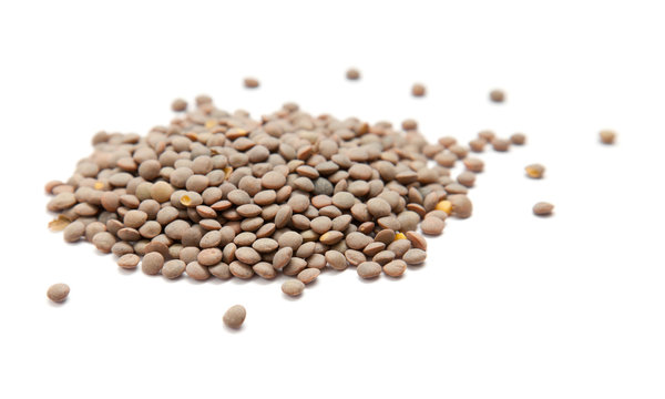 handful of brown lentils isolated on white background