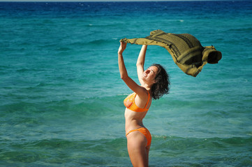 Beautiful young woman on the beach with a colored tissue