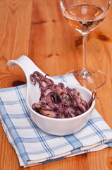 Tintenfisch als Salat und Weinglas mit Rose