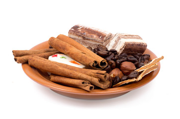 Sweets, cinnamon, nuts and coffee beans on a saucer