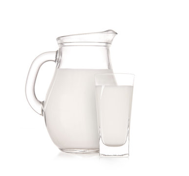 Milk jug with glass over white background