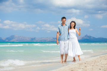 Fototapeta na wymiar Happy young couple walking on beach