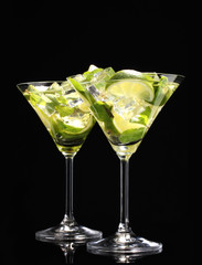 glasses of cocktails with lime and mint on black background
