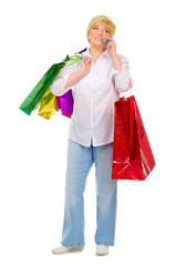 Senior woman with packets talking by mobile phone