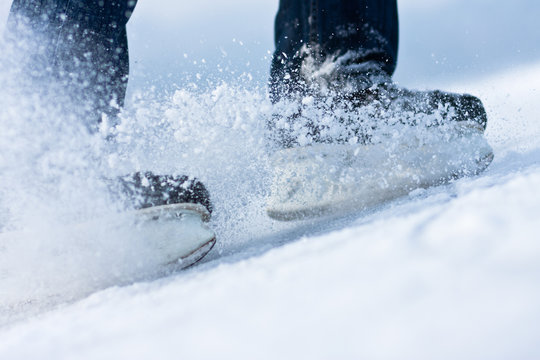 Two breaking ice skates with flying snow
