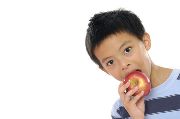 An young asian kid holding an apple